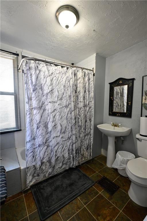 bathroom featuring toilet and a textured ceiling