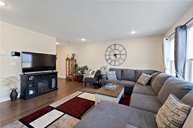 living area featuring recessed lighting, a textured ceiling, and wood finished floors