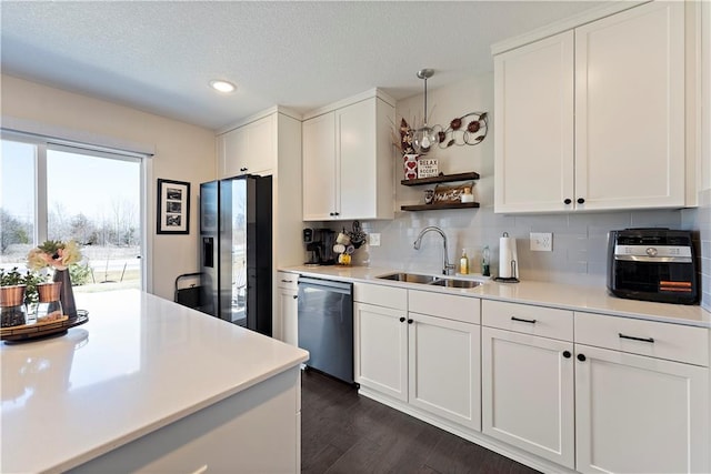 kitchen featuring tasteful backsplash, light countertops, stainless steel appliances, white cabinetry, and a sink