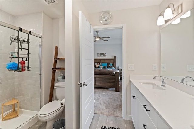 bathroom featuring a shower stall, connected bathroom, wood finish floors, toilet, and vanity