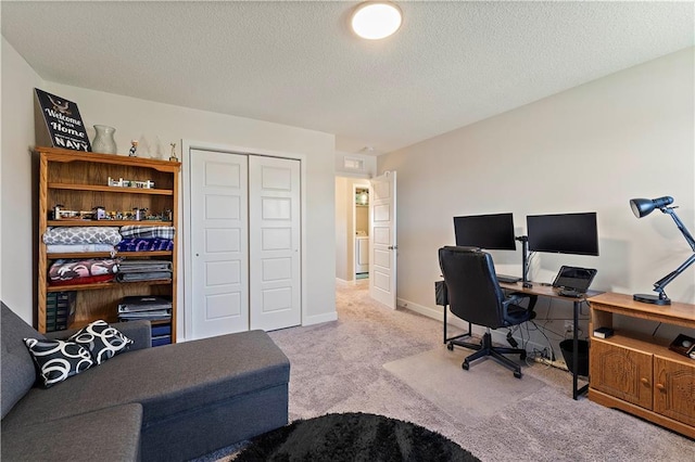 carpeted home office with baseboards and a textured ceiling