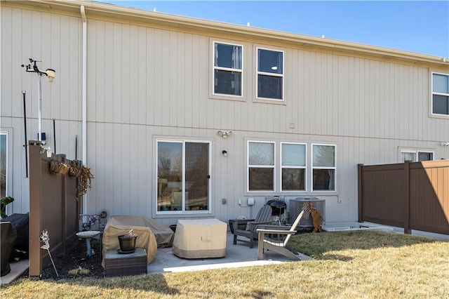 back of property featuring central air condition unit, a lawn, a patio area, and fence