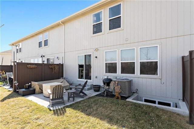 rear view of property featuring a patio area, a yard, central AC, and fence