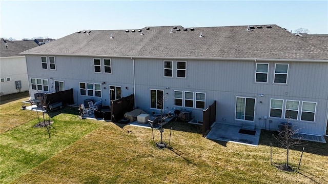 rear view of property featuring a patio area, a shingled roof, and a yard