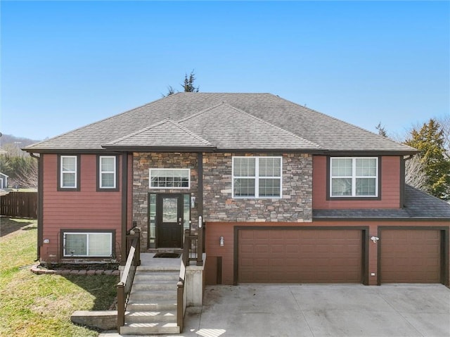 view of front of property featuring stone siding, an attached garage, a shingled roof, and driveway