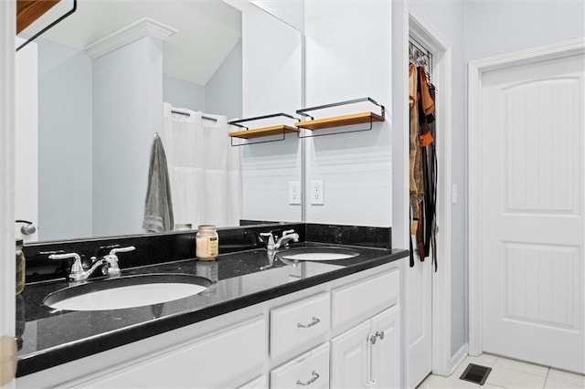 bathroom featuring double vanity, visible vents, tile patterned floors, and a sink