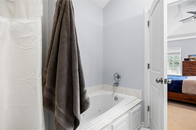 ensuite bathroom featuring connected bathroom and a tub with jets