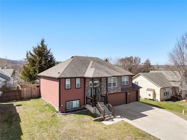 view of front of home with fence, concrete driveway, a front yard, a shingled roof, and a garage