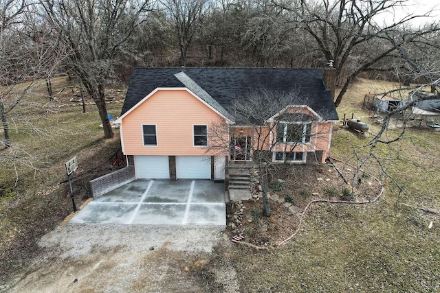 view of front facade featuring driveway, brick siding, roof with shingles, and an attached garage