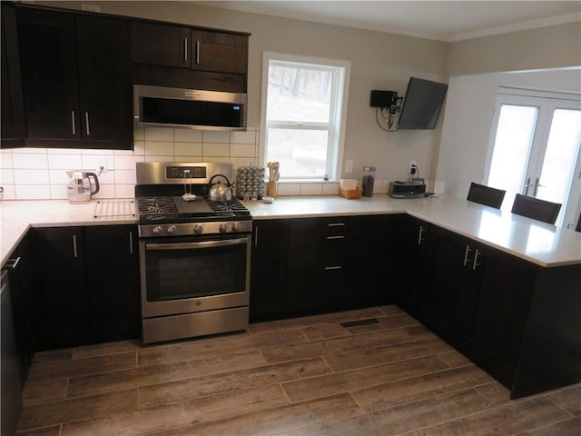 24243 Sandusky Rd, Tonganoxie, KS 66086 - kitchen featuring stainless steel appliances, dark wood finished floors, ornamental molding, tasteful backsplash, and light countertops