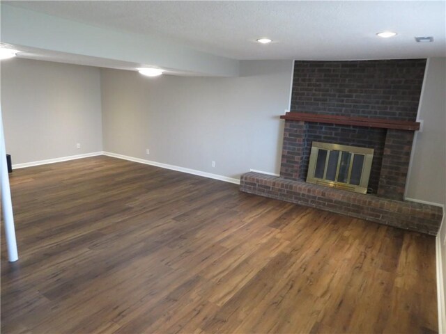 24243 Sandusky Rd, Tonganoxie, KS 66086 - unfurnished living room with dark wood-type flooring, baseboards, a fireplace, and recessed lighting
