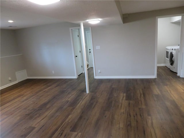 24243 Sandusky Rd, Tonganoxie, KS 66086 - finished basement with washer and clothes dryer, dark wood-style flooring, baseboards, and a textured ceiling