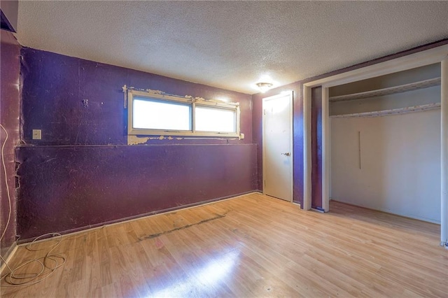 unfurnished bedroom with a textured ceiling and wood finished floors