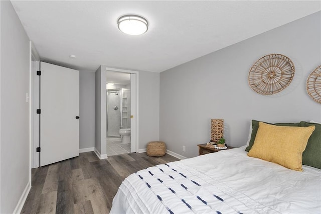 bedroom with baseboards, wood finished floors, and ensuite bathroom