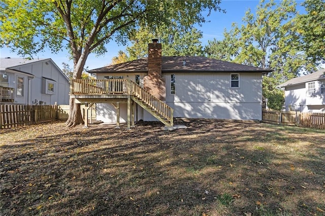 back of property featuring stairway, a chimney, a fenced backyard, and a wooden deck