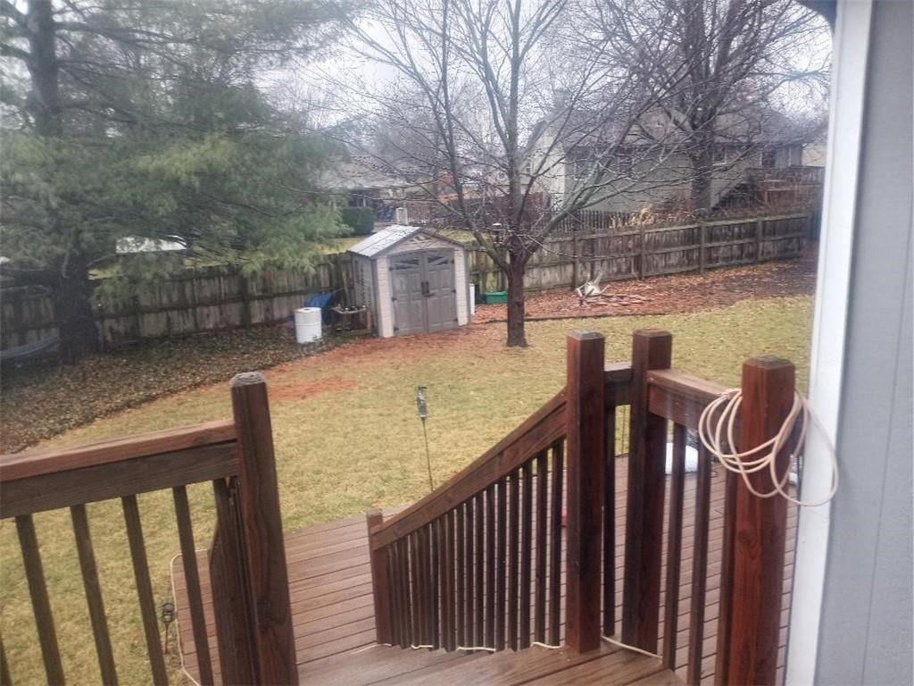 view of yard featuring a fenced backyard, a storage unit, and an outdoor structure