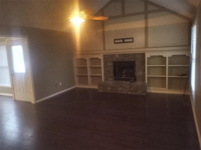 unfurnished living room featuring a fireplace with raised hearth, baseboards, and wood finished floors