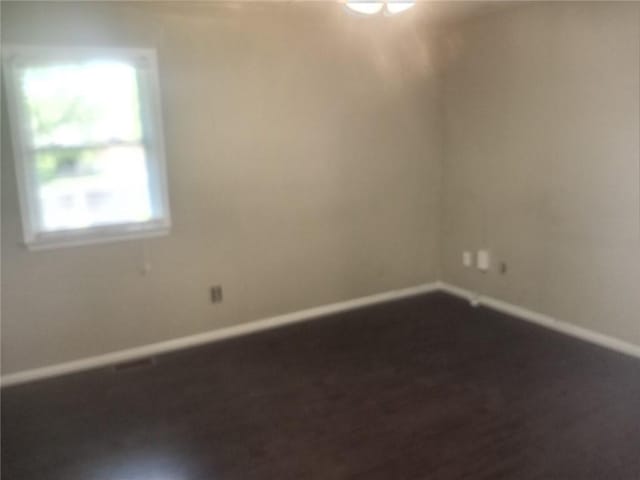 unfurnished room featuring dark wood finished floors and baseboards