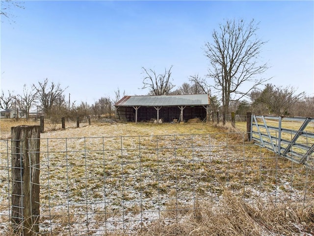 view of yard with an outbuilding, a pole building, a rural view, and fence