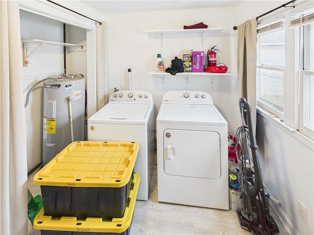 washroom with laundry area, washing machine and clothes dryer, and electric water heater