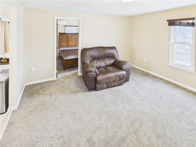 living area featuring baseboards and carpet flooring