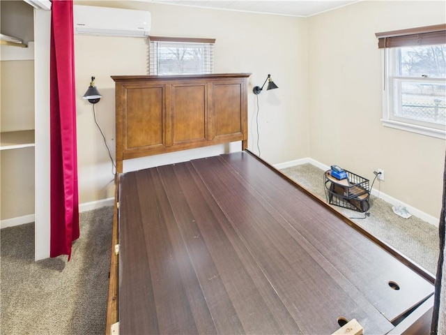 unfurnished bedroom featuring baseboards, dark colored carpet, and a wall mounted AC