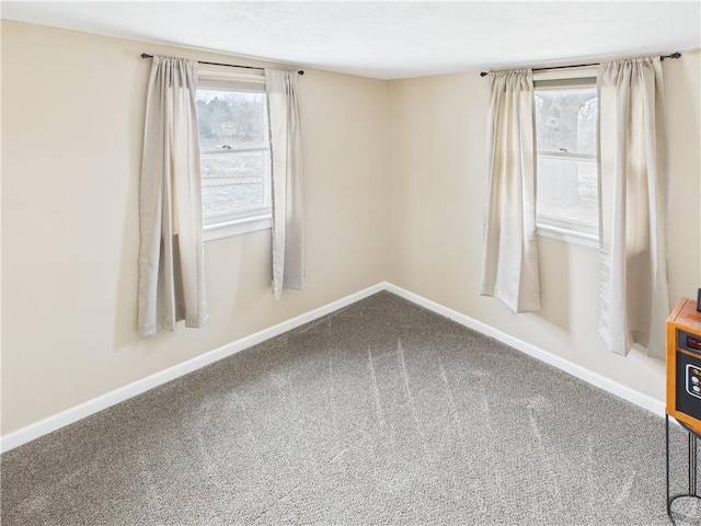 carpeted spare room with baseboards