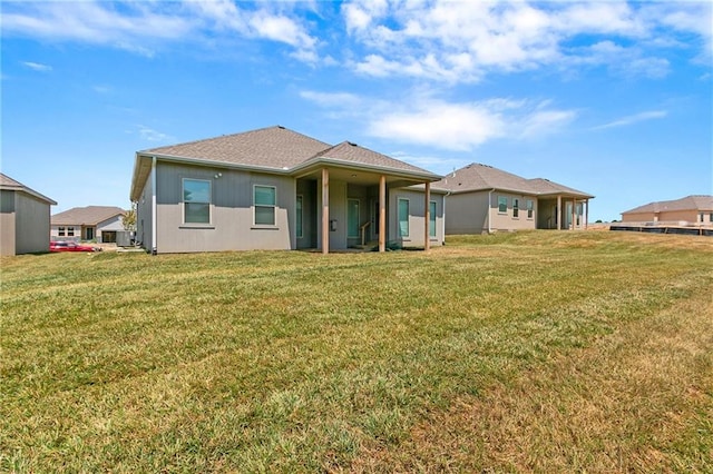 rear view of property with a yard