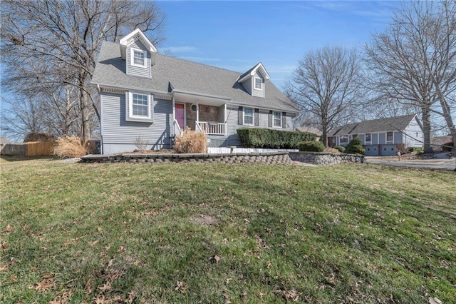 cape cod home featuring roof with shingles, a front yard, and fence