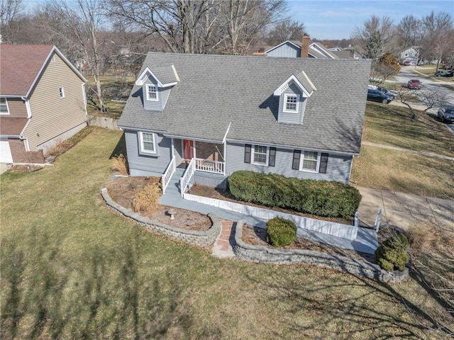 cape cod home with a porch, a shingled roof, and a front yard