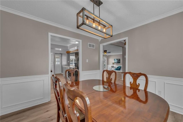 dining area featuring wainscoting and a textured ceiling