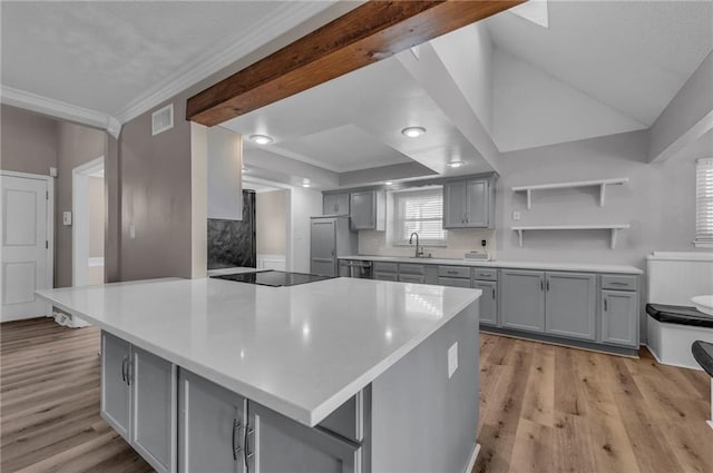 kitchen featuring visible vents, gray cabinetry, black electric stovetop, ornamental molding, and light wood-style flooring