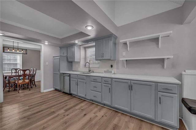 kitchen featuring a sink, light wood-style floors, stainless steel dishwasher, and gray cabinetry