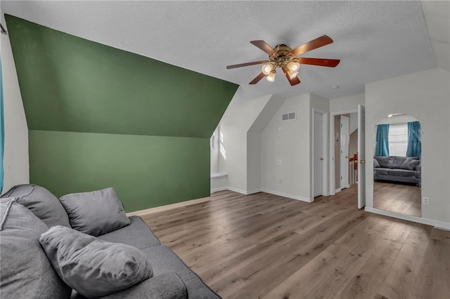 interior space with visible vents, a textured ceiling, baseboards, and wood finished floors