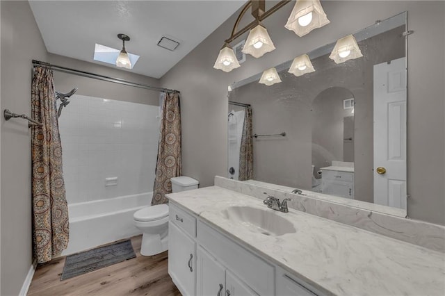 bathroom featuring vanity, toilet, wood finished floors, and shower / bath combo