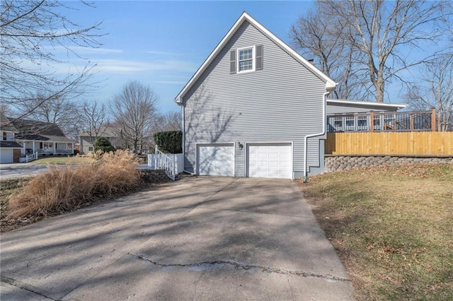 view of property exterior featuring concrete driveway and an attached garage