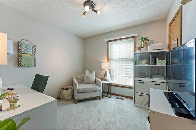 carpeted office featuring visible vents, baseboards, and a textured ceiling