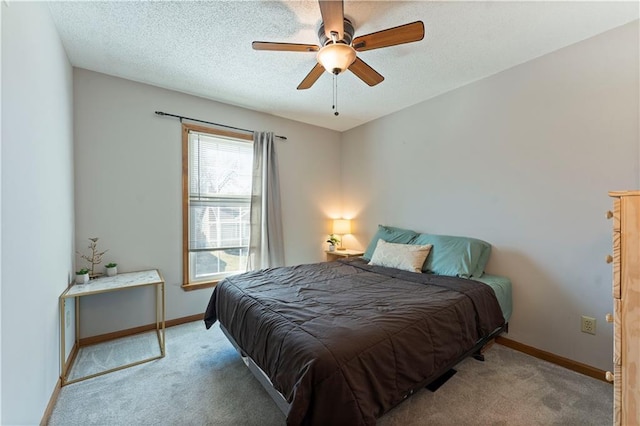 bedroom with light colored carpet, a textured ceiling, baseboards, and ceiling fan