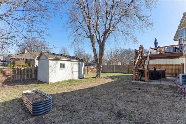 view of yard featuring an outbuilding, a wooden deck, stairs, and a fenced backyard