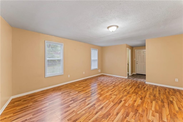 6418 E 150th St, Grandview, MO 64030 - empty room featuring light wood-style flooring, a textured ceiling, and baseboards