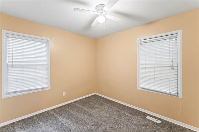 6418 E 150th St, Grandview, MO 64030 - spare room featuring dark colored carpet, ceiling fan, and baseboards