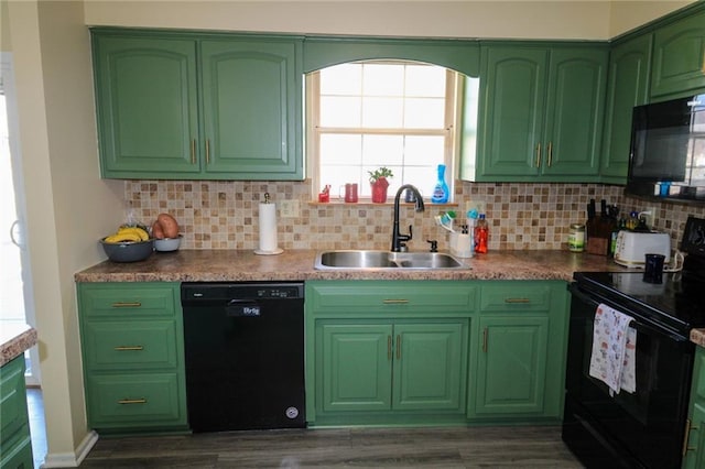 kitchen with green cabinets, black appliances, decorative backsplash, and a sink