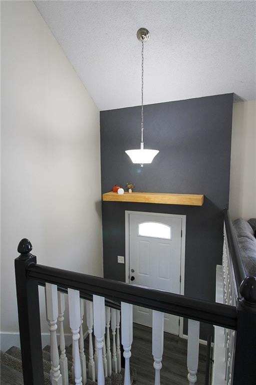 foyer with stairway, baseboards, a textured ceiling, and wood finished floors