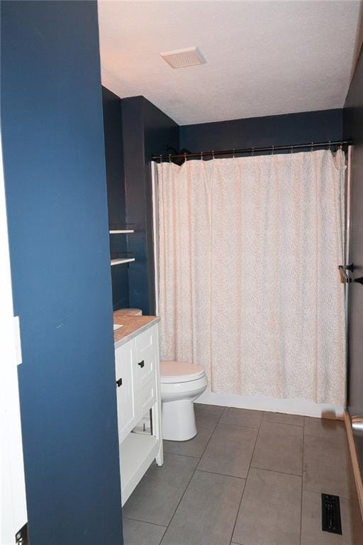 bathroom with curtained shower, tile patterned floors, toilet, and vanity