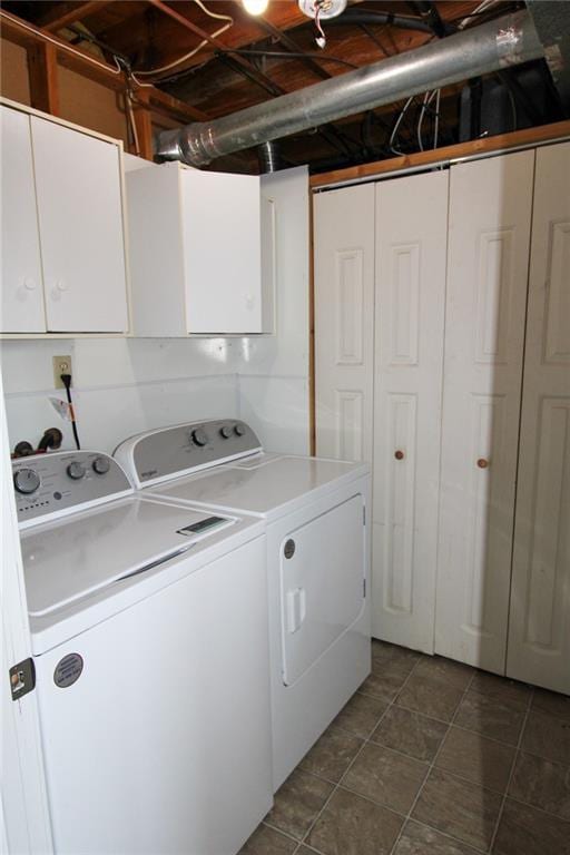 clothes washing area featuring washer and clothes dryer and cabinet space