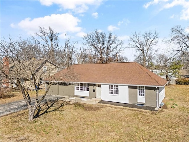 view of front of house with a front yard and a shingled roof