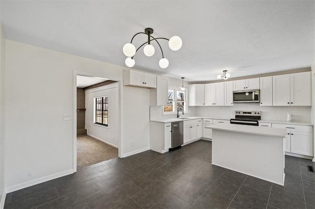 kitchen featuring a sink, stainless steel appliances, plenty of natural light, and white cabinets