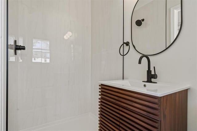 bathroom featuring vanity and tiled shower