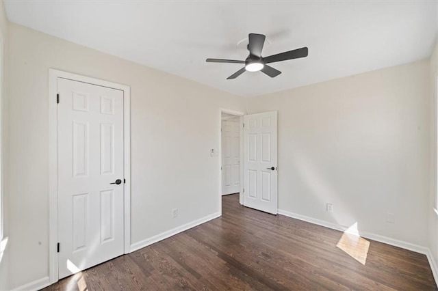 unfurnished bedroom with baseboards, wood finished floors, and a ceiling fan