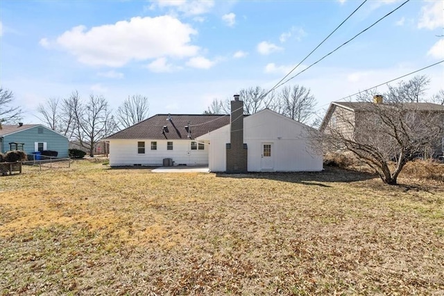 back of house featuring a patio area, a yard, fence, and a chimney